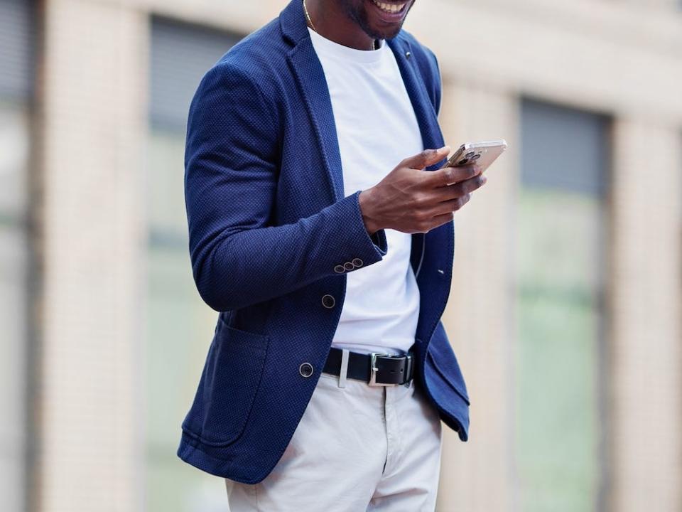 man wearing blue blazer looking at his phone