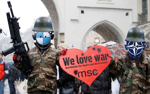  Protesters hold up a heart-shaped sign at a demonstration during the Munich Security Conference in Munich - Credit: MICHAELA REHLE/ REUTERS