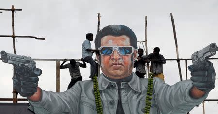 FILE PHOTO - Fans of south Indian film star Rajinikanth pour milk as an offering over his cut-out on the release date of his new movie "Endhiran" (Robot) in the southern Indian city of Chennai, India, October 1, 2010. REUTERS/Babu/File Photo