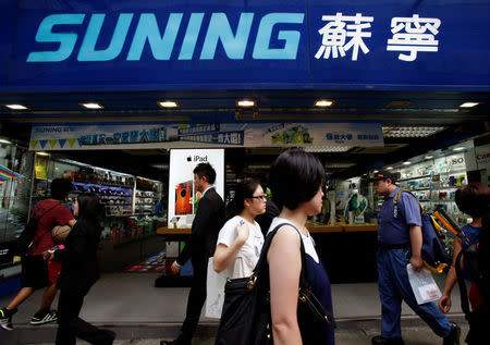 People walk past a Suning store, one of the largest home appliance retailers in China, in Hong Kong August 26, 2013. REUTERS/Bobby Yip/File Photo