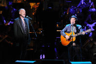 Musicians Sting, left, and Paul Simon perform the song "Bridge Over Troubled Water" together at the 25th Anniversary Rainforest Fund benefit concert at Carnegie Hall on Thursday, April 17, 2014 in New York. (Photo by Evan Agostini/Invision/AP)