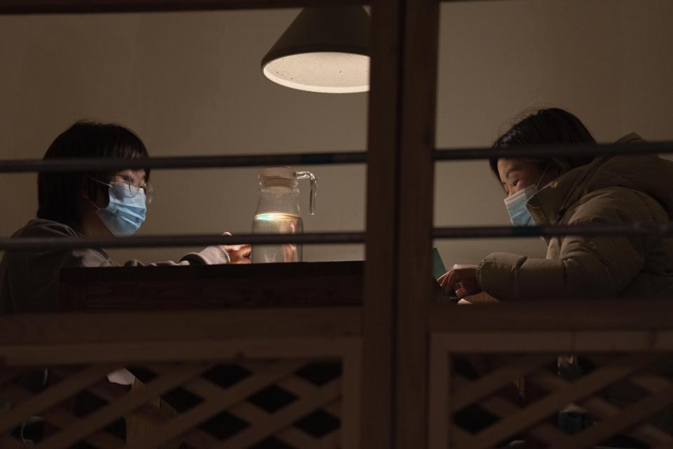 Customers wear masks as they sit down to order food at the Little Yunnan restaurant in Beijing, Wednesday, Dec. 28, 2022. After three years of quarantines pushed them close to shutting down, restaurant owner Li Meng and his wife are hoping for business to rebound after China rolled back severe anti-virus controls. But now they face a new challenge: Fear of its wave of infections is keeping diners away. (AP Photo/Ng Han Guan)