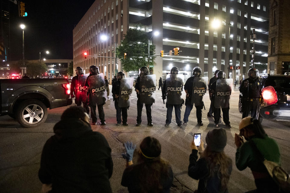 Protesters kneel in prayer in front of Detroit police as hundreds gather to protest over the death of George Floyd Friday, May 29, 2020, in Detroit. Floyd died in police custody Monday in Minneapolis. (Nicole Hester/Ann Arbor News via AP)
