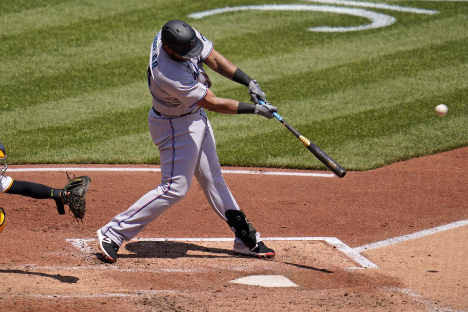 Miami Marlins' Jesus Aguilar hits a sacrifice fly to right field off Pittsburgh Pirates starting pitcher Chad Kuhl, driving in a run, during the sixth inning of a baseball game in Pittsburgh, Sunday, June 6, 2021. (AP Photo/Gene J. Puskar)