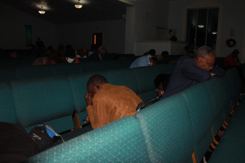 Parishioners kneel and pray-in the new year under dimmed lights at DaySpring Baptist Church during a joint Watch Night service held at the church with Emanuel Baptist Church.
(Photo: Photo by Voleer Thomas/For The Guardian)