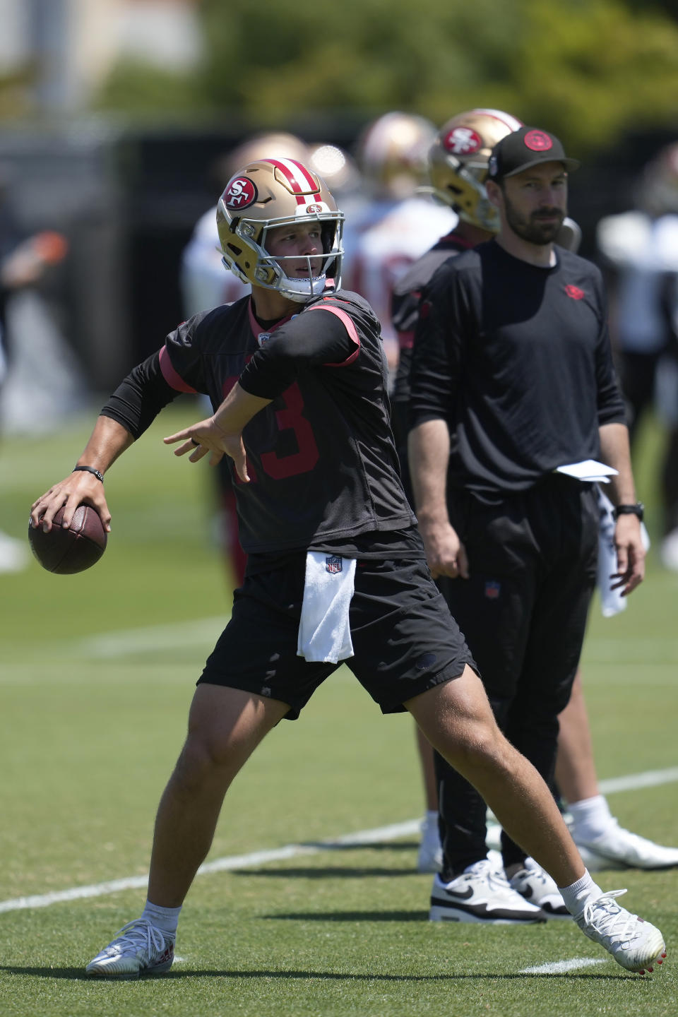 San Francisco 49ers quarterback Brock Purdy, left, throws a pass in front of assistant quarterbacks coach Klay Kubiak during NFL football practice in Santa Clara, Calif., Tuesday, May 21, 2024. (AP Photo/Jeff Chiu)