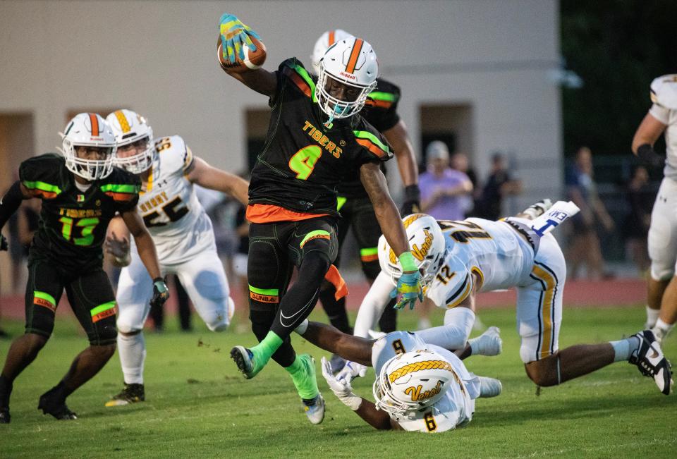 Tawaski Abrams of Dunbar jumps out of reach of Jeremiah Dean of Bishop Verot on Friday, Sept. 8, 2023, at Dunbar High School in Fort Myers.