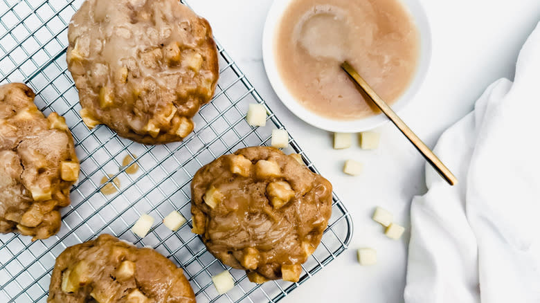 fritters with chopped apples on wire rack with glaze