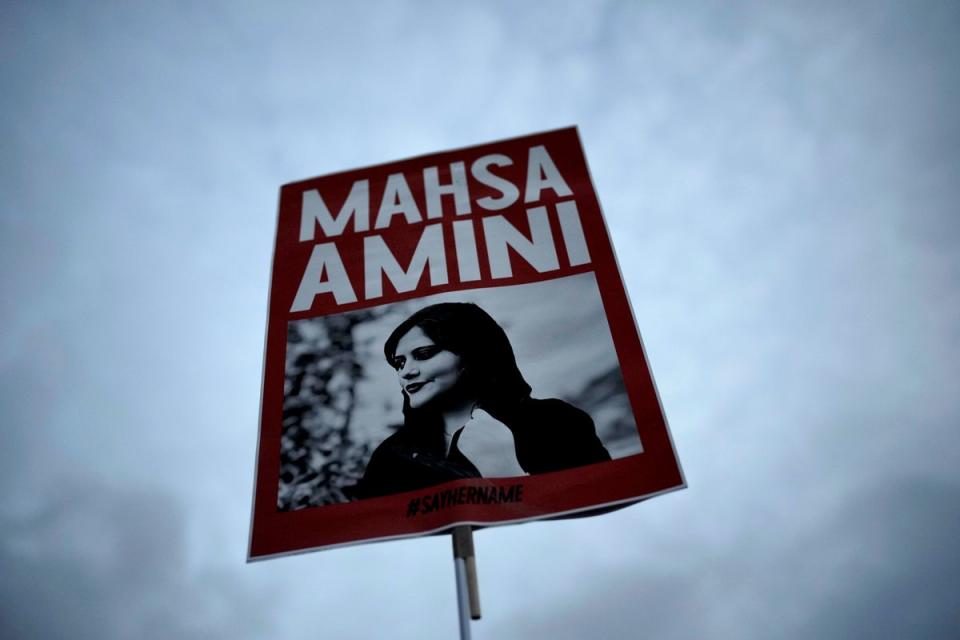 A woman holds a placard with a picture of Iranian woman Mahsa Amini during a protest against her death (Copyright 2022 The Associated Press. All rights reserved)