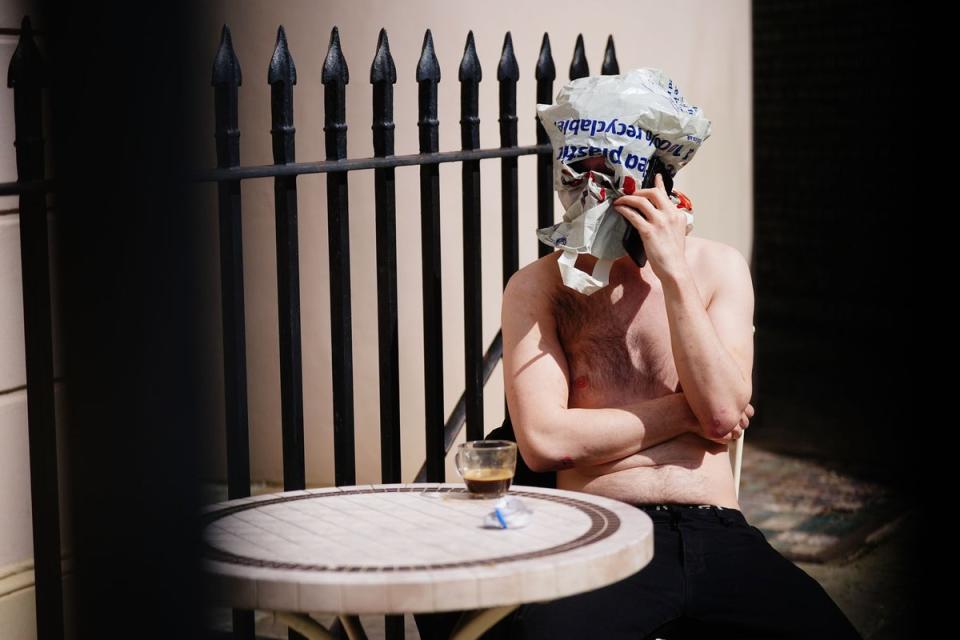 A squatter with a bag over his head has a drink outside the York & Albany pub (Victoria Jones/PA Wire)