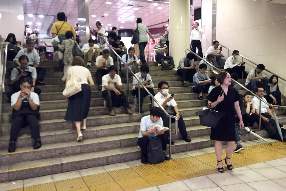 Passengers wait outside of the station platform as train operations are suspended due to Typhoon Faxai at Totsuka Station Monday, Sept. 9, 2019, in Yokohama, south of Tokyo. The typhoon blew across the Tokyo metropolitan area Monday morning, killing one person and causing dozens of injuries while disrupting rush-hour travel and knocking out power. (AP Photo/Koji Sasahara)