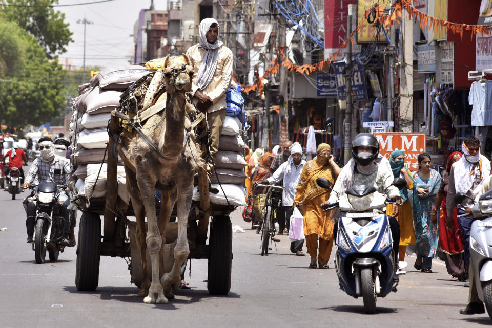 FILE- Commuters cover their faces with scarves to protect themselves from the harsh heat in Bikaner, Rajasthan, India, Thursday, May 23, 2024. A monthslong heatwave across swathes of India has killed more than 100 people and led to over 40,000 suspected cases of heat stroke in the last three and a half months, a Health Ministry official said Thursday, June 20. (AP Photo/Dinesh Gupta, File)