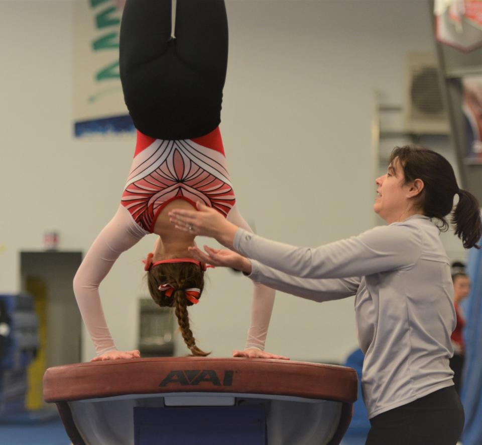 Norwich Free Academy gymnastics coach Tandi Carignan helps earn some trust on the vault during her first season.