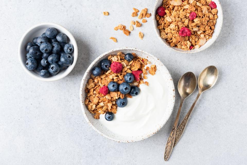 yogurt bowl with granola and blueberries on grey background, table top view breakfast food