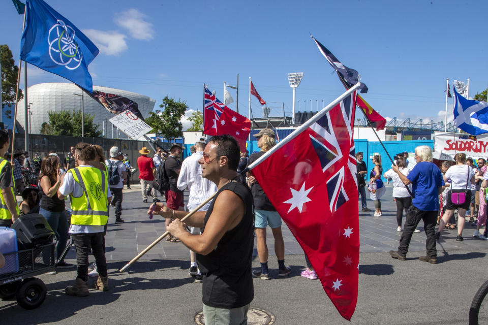 Manifestantes antivacuna se concentran fuera de Melbourne Park después que trascendió que Novak Djokovic aparentemente pasó a un hotel de detención de inmigrantes en Melbourne, Australia, sábado 15 de enero de 2021. (AP Foto/Mark Baker)