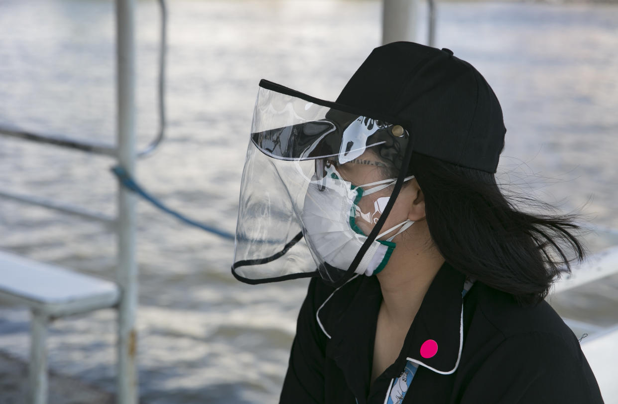 BANGKOK, THAILAND - MARCH 27:  A woman wears a mask on a commuter boat as Thailand imposed a state of emergency to combat the spread of the coronavirus (COVID-19) on March 27, 2020 in Bangkok, Thailand.  It is now compulsory to wear a mask while using public transportation. Thailand's Department of Disease Control has confirmed 91 new cases of the virus and are advising people to stay home.  (Photo by Allison Joyce/Getty Images)