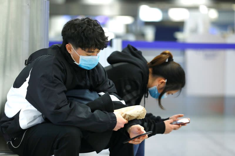 Travellers wear protective masks at Frankfurt Airport