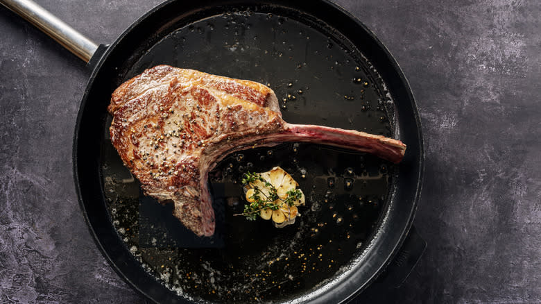 Tomahawk steak frying in pan