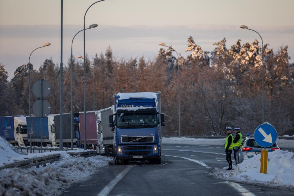 Police officers stand as trucks belonging to different Polish transport company owners block the access to Polish-Ukraine border crossing in protest against ‘unfair' competition in Hrebenne, Poland (AFP via Getty Images)