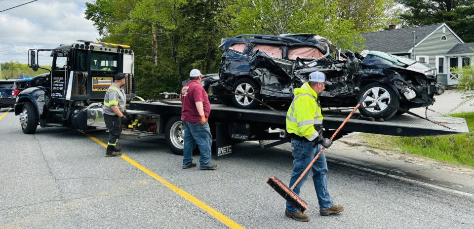A crew prepares to tow away a vehicle damaged in a collision with a tractor trailer truck at the intersection of Route 4 and New Dam Road in Sanford, Maine, on Monday, May 20, 2024.