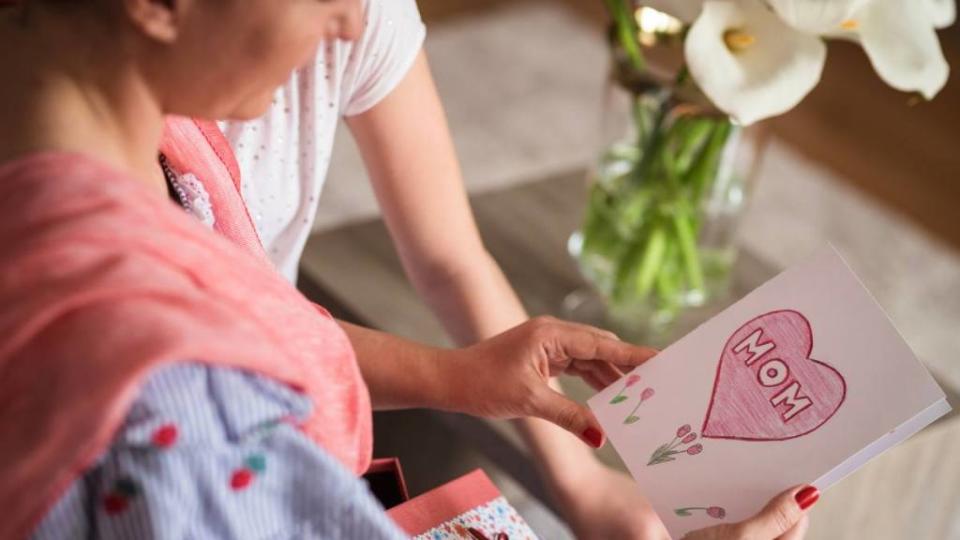 Mom and child looking at a Mother's Day card together