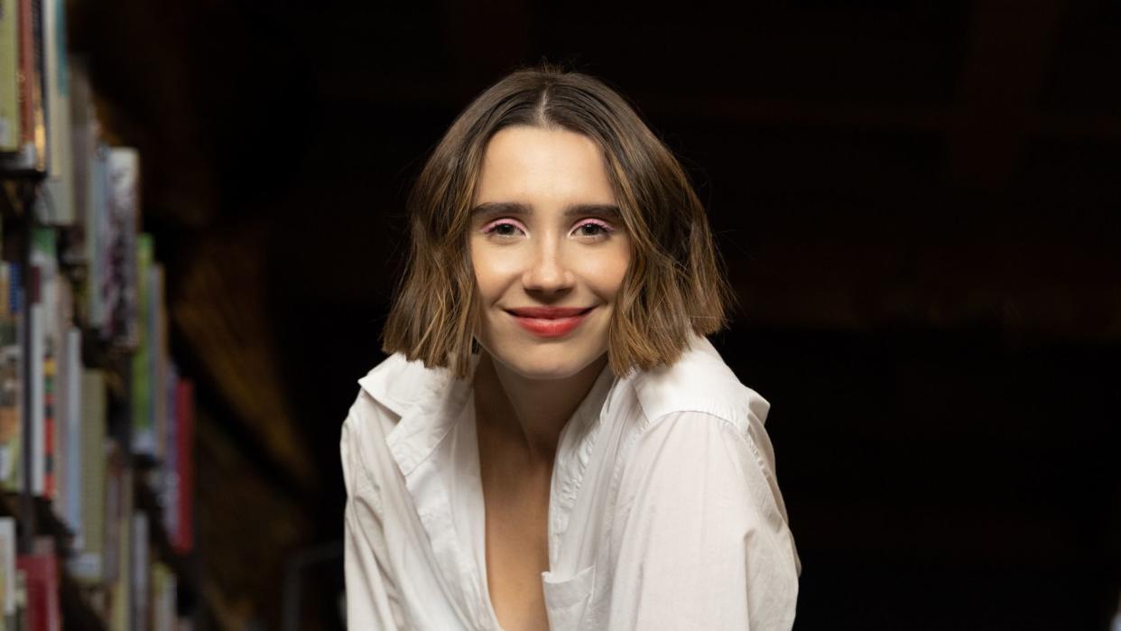 amanda montell standing in front of a bookshelf