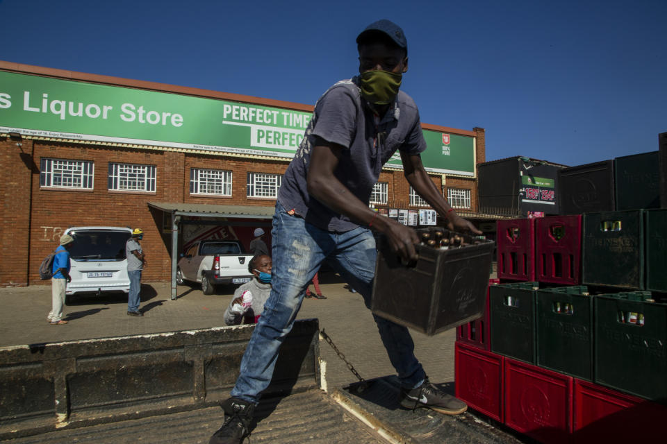 A worker loads alcoholic beverages outside the Sam Liquor Store in Thokoza township, near Johannesburg, South Africa, Monday, June 1, 2020. Liquor stores have reopened Monday after being closed for over two months under lockdown restrictions in a bid to prevent the spread of coronavirus.(AP Photo/Themba Hadebe)