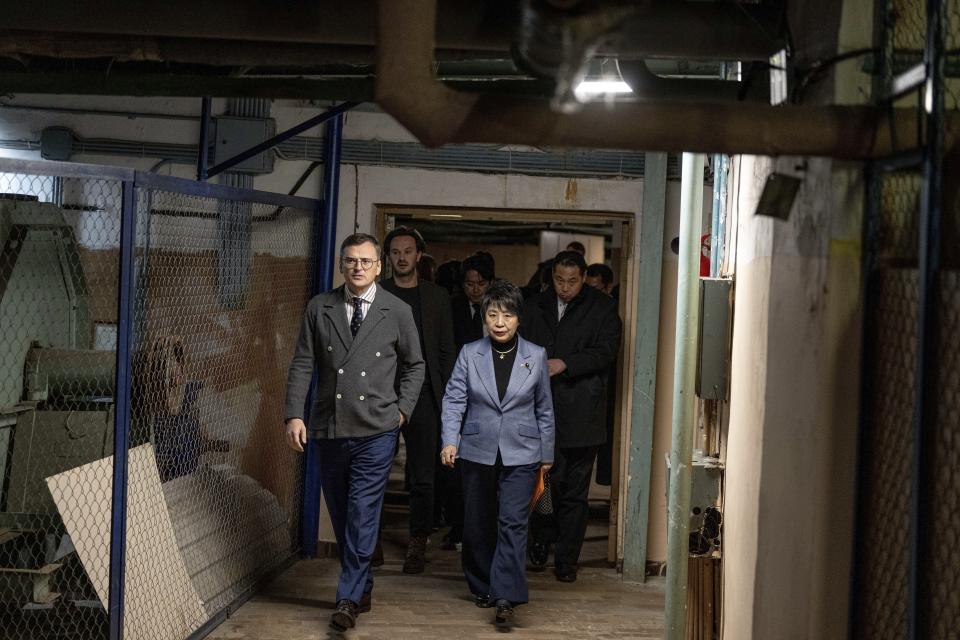 Ukraine's Foreign Minister Dmytro Kuleba guides Japan's Foreign Minister Yoko Kamikawa, right, along a corridor of a bomb shelter during air alert in Kyiv, Ukraine, on Sunday, Jan. 7, 2024. (AP Photo/Evgeniy Maloletka)