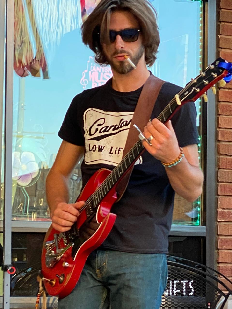 Hunter Schwenk plays guitar for Urban Honey outside Gator's Joint in downtown Canton in the summer of 2021. Earlier this summer, Urban Honey released its first studio recordings on a four-song EP.