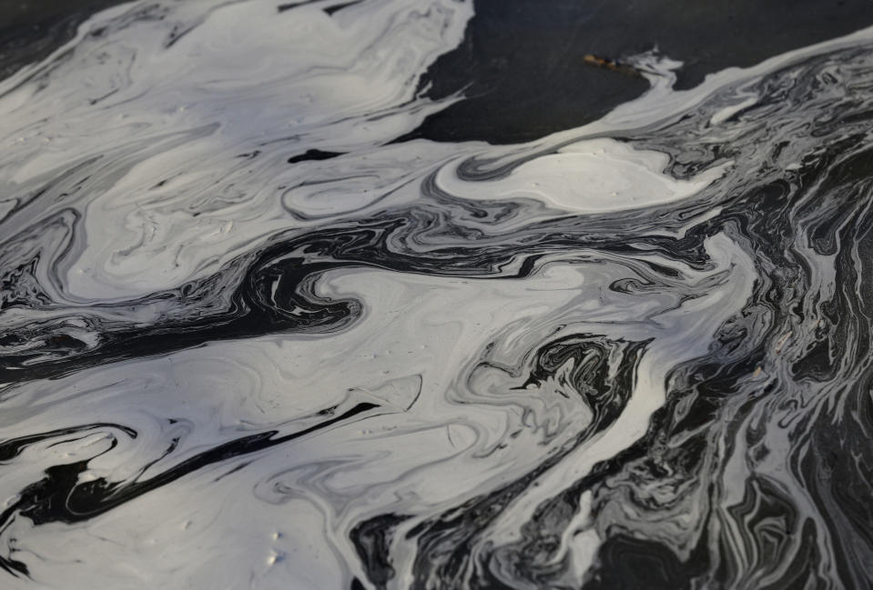 Coal ash swirls on the surface of the Dan River as state and federal environmental officials continued their investigations of a spill of coal ash into the river in Danville, Va., Wednesday, Feb. 5, 2014. Duke Energy estimates that up to 82,000 tons of ash has been released from a break in a 48-inch storm water pipe at the Dan River Power Plant in Eden N.C. on Sunday. (AP Photo/Gerry Broome)