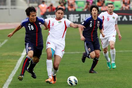 Japan's Ryoichi Maeda (L) and Atsuto Uchida (2nd R) fight for the ball with Jordan's Saeed Morjan (2nd L) and Odai al-Saify during their 2014 World Cup qualifying soccer match at King Abdullah stadium in Amman March 26, 2013. REUTERS/Muhammad Hamed