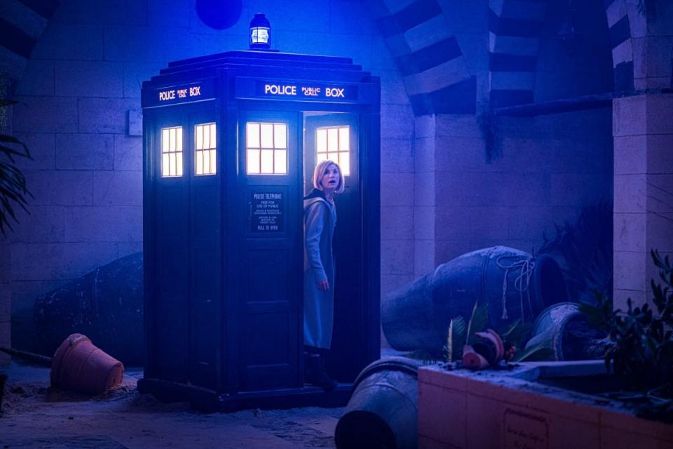 the thirteenth doctor steps out of the tardis into a dark room