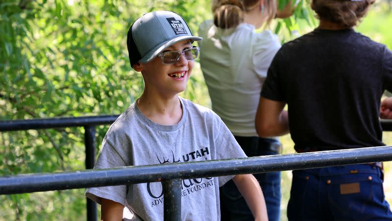 Twelve-year-old Hazen Stokes tries to get in some fishing with his older brother, Sloan, as he and his family pose for photos at Glasmann Pond in Ogden on Saturday, July 29, 2023. Hazen was born prematurely, and has had numerous surgeries to deal with health issues in his young life.