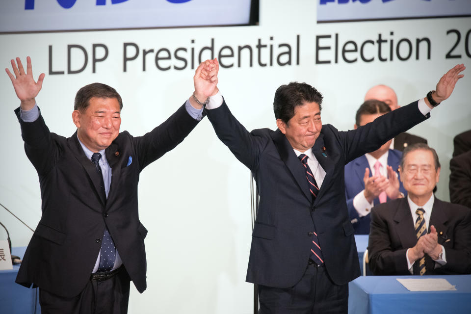 <p>Japan’s Prime Minister Shinzo Abe (R) celebrates with Shigeru Ishiba, the former defence minister who ran against him, after winning the Liberal Democratic Party leadership contest on September 20, 2018 in Tokyo, Japan. Prime Minister Abe has been re-elected for a third consecutive term as leader of the ruling Liberal Democratic Party and is now the longest serving Prime Minister since World War Two. (Photo by Carl Court/Getty Images) </p>