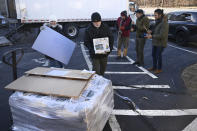 Andy Thibault, Editor and Publisher of The Winsted Citizen, carries the first bundle of papers off a pallet as Advertising and Circulation Director Rosemary Scanlon holds the first print press plate while a group of musicians play behind them after the arrival of the first delivery of the paper on, Friday, Feb. 3, 2023, in Winsted, Conn. At a time that local newspapers are dying at an alarming rate, longtime activist Ralph Nader is helping give birth to one. Nader put up $15,000 to help launch The Winsted Citizen and hired a veteran Connecticut journalist, Andy Thibault, to put it together. (AP Photo/Jessica Hill)