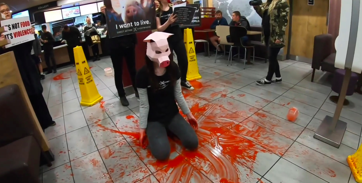 Vegan activist Dylan Roffey wearing a pig mask during a protest in a McDonald's (PA)