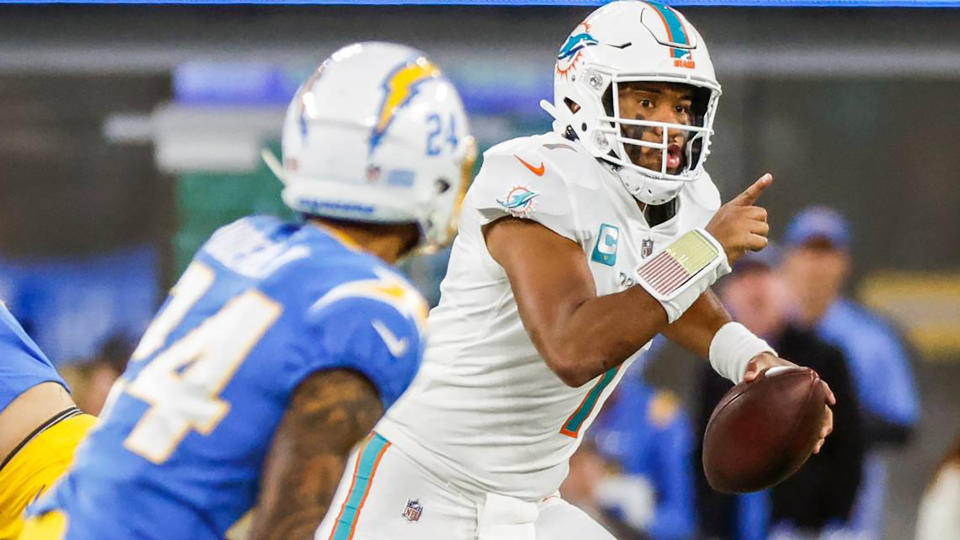 Miami Dolphins quarterback Tua Tagovailoa (1) scrambles as Los Angeles Chargers safety Nasir Adderley (24) gives chase in the fourth quarter at SoFi Stadium on Dec. 11, 2022, in Inglewood, California. (Al Diaz/Miami Herald/Tribune News Service via Getty Images)