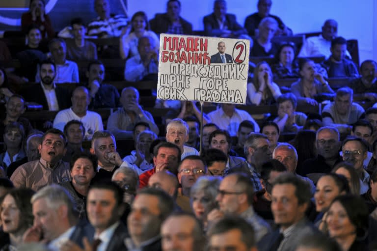 A supporter of opposition candidate Mladen Bojanic holds a banner reading "Mladen Bojanic is the president of all citizens of Montenegro"