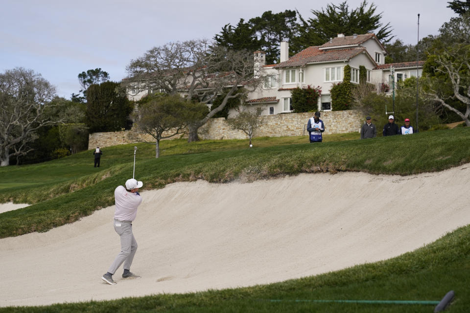 Nate Lashley hits out of a bunker up to the first green of the Pebble Beach Golf Links during the final round of the AT&T Pebble Beach Pro-Am golf tournament Sunday, Feb. 14, 2021, in Pebble Beach, Calif. Jordan Spieth, third from right, and Tom Hoge, second from right, look on. (AP Photo/Eric Risberg)