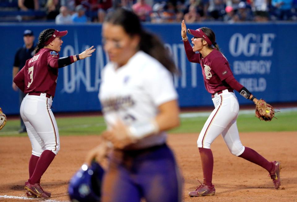 Florida State's Bethaney Keen (3) and Devyn Flaherty (9) celebrate as Washington's Megan Vandegrift (2) walks off the field during a softball game between Washington and Florida State in the Women's College World Series at USA Softball Hall of Fame Stadium in  in Oklahoma City, Saturday, June, 3, 2023. 