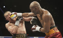 Beibut Shumenov, left, of Kazakhstan, takes a punch from Bernard Hopkins, right, of the United States, during their IBF, WBA and IBA Light Heavyweight World Championship unification boxing match, Saturday, April 19, 2014, in Washington. Hopkins won by a split decision. (AP Photo/Luis M. Alvarez)