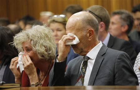 Arnold Pistorius (R), uncle of South African Olympic and Paralympic sprinter Oscar Pistorius, wipes his tears as the athlete gives evidence during his trial at the high court in Pretoria April 8, 2014. REUTERS/Kim Ludbrook/Pool