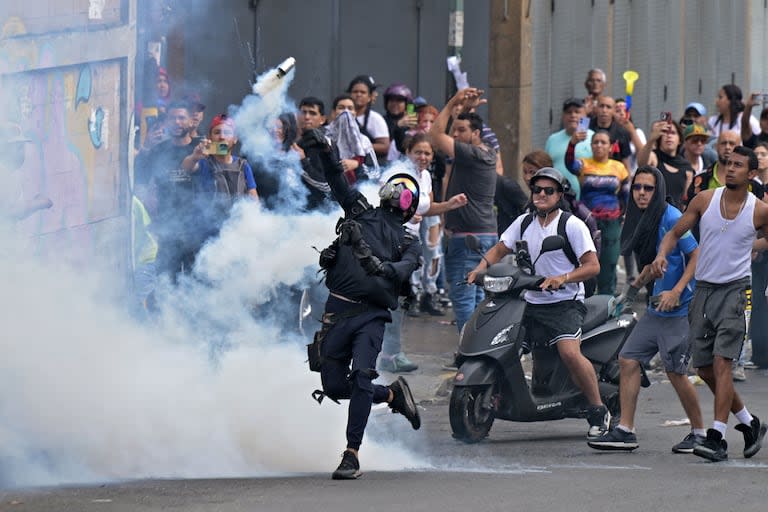 Manifestantes se enfrentan con la policía antidisturbios durante una protesta en el barrio Catia de Caracas.