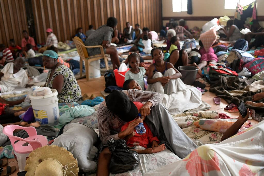 Earthquake-displaced people sit inside a church the morning after Tropical Storm Grace swept over Les Cayes, Haiti, Tuesday, Aug. 17, 2021, three days after a 7.2 magnitude quake. (AP Photo/Matias Delacroix)