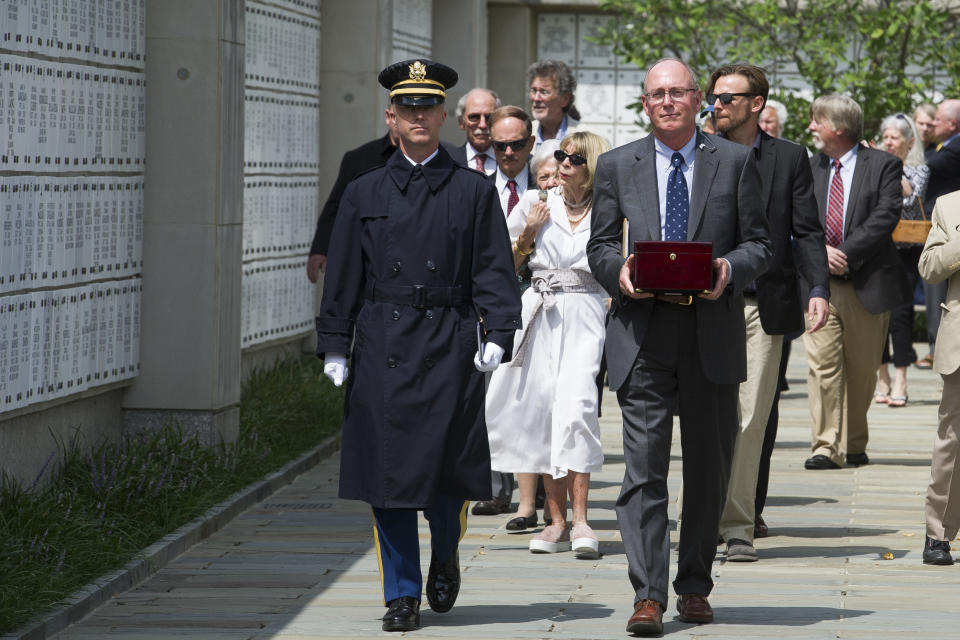 The remains of longtime Associated Press journalist Richard Pyle are carried by Arlington National Cemetery representative Jeffrey Aaron, right, in the columbarium where Pyle will be interned, with military honors, at Arlington National Cemetery, Monday, Aug. 20, 2018, in Arlington, Va. (AP Photo/Cliff Owen)