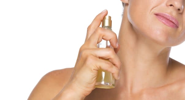 Closeup on young woman applying perfume