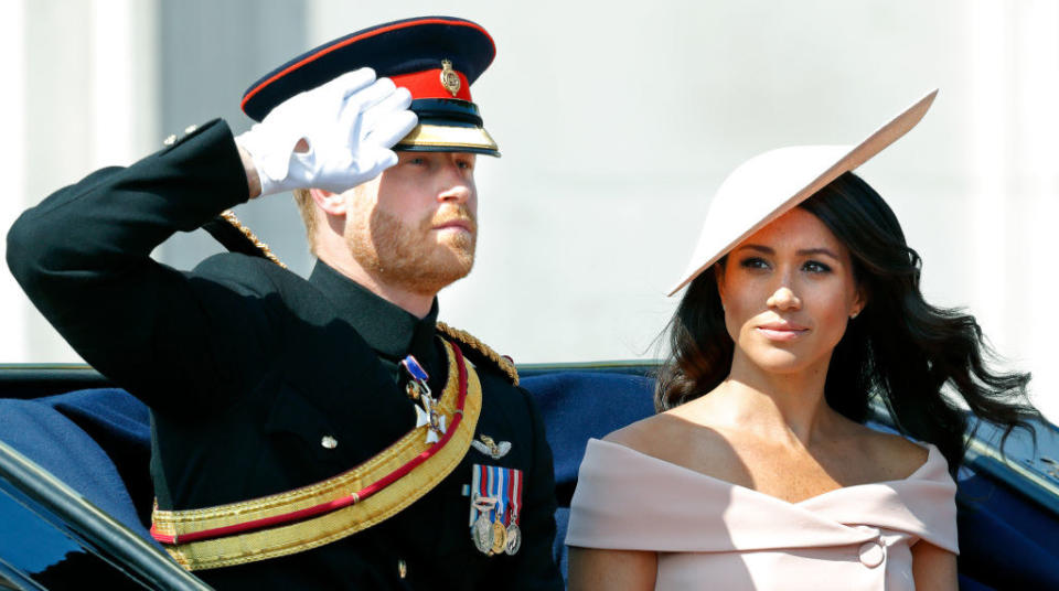 Harry saluting with Meghan next to him