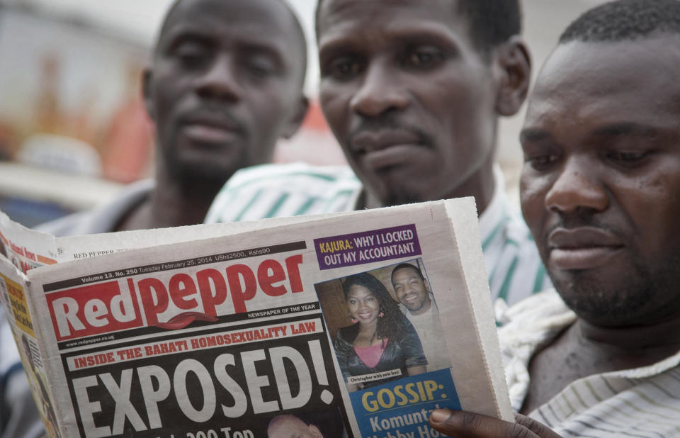 A Ugandan reads a copy of the "Red Pepper" tabloid newspaper in Kampala, Uganda Tuesday, Feb. 25, 2014. The Ugandan newspaper published a list Tuesday of what it called the country's "200 top" homosexuals, outing some Ugandans who previously had not identified themselves as gay, one day after the president Yoweri Museveni enacted a harsh anti-gay law. (AP Photo/Rebecca Vassie)
