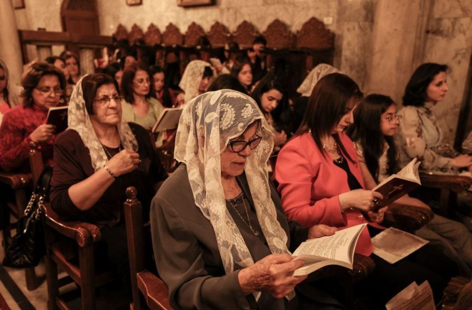 Palestinian Christians attend an Orthodox service during Easter night at the Church of Saint Porphyrius