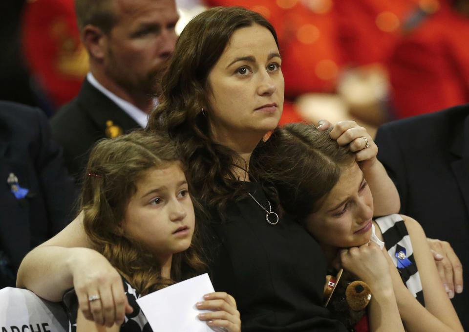 The family of Royal Canadian Mounted Police officer Douglas James Larche, one of three officers who were killed last week, reacts during a regimental funeral Moncton